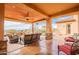 Large covered patio showcasing desert views, a stone fireplace, and comfortable outdoor seating arrangements at 3086 N Herrala Way, Apache Junction, AZ 85119