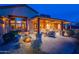 Back exterior view showcasing a covered patio with stone columns, desert landscaping, and a mountain backdrop at 3086 N Herrala Way, Apache Junction, AZ 85119