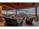 Expansive covered patio features comfortable seating areas with desert views and a stone fireplace at 3086 N Herrala Way, Apache Junction, AZ 85119
