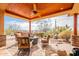 Covered patio featuring a ceiling fan, desert landscaping, stone supports, and a built-in grill at 3086 N Herrala Way, Apache Junction, AZ 85119