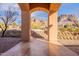 Inviting exterior view through an archway framing the desert landscaping and mountains in the distance, creating an alluring scene at 3086 N Herrala Way, Apache Junction, AZ 85119
