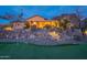 Inviting home exterior with meticulously landscaped rock yard, mature desert trees, and a putting green at 3086 N Herrala Way, Apache Junction, AZ 85119