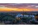 Expansive aerial view of a home nestled among desert foliage with captivating city lights and mountain views in the background at 3086 N Herrala Way, Apache Junction, AZ 85119