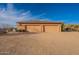 Exterior view of a three car garage with neutral paint and desert landscaping at 3086 N Herrala Way, Apache Junction, AZ 85119