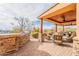 Covered patio showcases the outdoor grill area with comfortable seating and desert landscape views at 3086 N Herrala Way, Apache Junction, AZ 85119