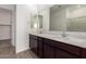 Bathroom featuring double sinks, quartz countertops, dark wood cabinetry, and large mirror at 31476 N Hayweather Ln, San Tan Valley, AZ 85143