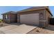 New construction home featuring a two-car garage and low maintenance desert landscaping at 31476 N Hayweather Ln, San Tan Valley, AZ 85143