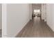 Bright hallway featuring wood-look tile flooring leading to the living area with lots of natural light at 31476 N Hayweather Ln, San Tan Valley, AZ 85143