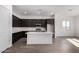 Modern kitchen with dark cabinets, white countertops, stainless steel appliances, and a center island at 31476 N Hayweather Ln, San Tan Valley, AZ 85143