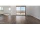 Bright living room with wood-look tile flooring, sliding glass door to back patio, and white walls at 31476 N Hayweather Ln, San Tan Valley, AZ 85143