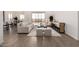 Open-concept living room with wood-look tile flooring, neutral decor, and access to the backyard at 31476 N Hayweather Ln, San Tan Valley, AZ 85143