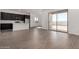 Open concept living room and kitchen featuring wood-look tile flooring and abundant natural light at 31476 N Hayweather Ln, San Tan Valley, AZ 85143