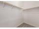 Spacious walk-in closet with carpeted floors and white walls featuring two wooden racks for storage at 31476 N Hayweather Ln, San Tan Valley, AZ 85143