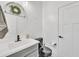 Chic powder room featuring a round mirror, white vanity with dark fixtures, and a modern toilet at 367 N 157Th Ln, Goodyear, AZ 85338