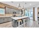 Bright kitchen with stainless steel appliances, gray cabinetry, exposed brick and island with barstool seating at 367 N 157Th Ln, Goodyear, AZ 85338