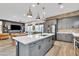 Bright, modern kitchen with gray cabinets, exposed brick, a large island and open floor plan at 367 N 157Th Ln, Goodyear, AZ 85338