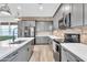 Modern kitchen features grey cabinets, exposed brick backsplash, stainless steel appliances and a large island at 367 N 157Th Ln, Goodyear, AZ 85338