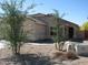 Exterior view of a single-story home, showcasing desert landscaping and a covered entryway at 44493 W Cypress Ln, Maricopa, AZ 85138