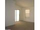 Bright, airy living room with neutral carpet, a sliding door and a large window at 44493 W Cypress Ln, Maricopa, AZ 85138