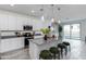 Bright kitchen features an island, modern lighting, stainless appliances, and a view into the living space at 651 N Ironwood Dr # 1, Apache Junction, AZ 85120