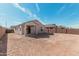 Wide angle exterior view of home's backyard featuring dirt, covered patio and block wall at 6722 W Desert Dr, Laveen, AZ 85339