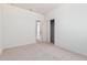Bedroom with neutral carpet, white walls, closet, and doorway view into another room at 6722 W Desert Dr, Laveen, AZ 85339