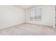 Bright bedroom featuring a large window and neutral carpeting at 6722 W Desert Dr, Laveen, AZ 85339