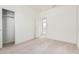 Bright bedroom featuring neutral carpet, white walls, closet, and doorway view into another room at 6722 W Desert Dr, Laveen, AZ 85339