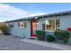 Well-maintained home exterior featuring a vibrant red door, manicured bushes, and ample natural light, creating curb appeal at 7407 E Polk St, Scottsdale, AZ 85257