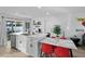 Bright kitchen features stainless steel appliances, white cabinets, a large island with seating, and modern fixtures at 7407 E Polk St, Scottsdale, AZ 85257
