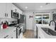 Modern kitchen boasts stainless steel appliances, white cabinets, a large island with seating, and access to the backyard at 7407 E Polk St, Scottsdale, AZ 85257