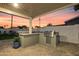 Outdoor kitchen features a built-in grill, tiled bar, and a view of the lush backyard, great for entertaining at 7407 E Polk St, Scottsdale, AZ 85257