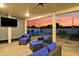 Inviting covered patio with a TV and comfortable seating, offering a glimpse of the sparkling pool and sunset views at 7407 E Polk St, Scottsdale, AZ 85257