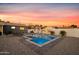 Backyard pool with gray tile, rock landscape, and painted mural, perfect for outdoor entertaining and relaxation at sunset at 7407 E Polk St, Scottsdale, AZ 85257
