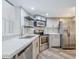 Well-equipped kitchen with stainless appliances, marble countertops, and a unique honeycomb backsplash at 7675 E Mcdonald Dr # 222, Scottsdale, AZ 85250