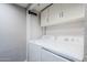 Dedicated laundry area with overhead storage cabinets and white washer and dryer at 7675 E Mcdonald Dr # 222, Scottsdale, AZ 85250