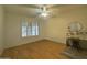 Bedroom with plantation shutters, wood floors, ceiling fan, and vanity area at 8611 W Village Dr, Peoria, AZ 85382