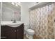 Bathroom with a vanity, toilet, and shower-tub combo with a stylish curtain, offering functionality at 8920 N 56Th Ave, Glendale, AZ 85302