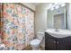 Cozy bathroom features updated vanity with solid surface counters and decorative shower curtain at 8920 N 56Th Ave, Glendale, AZ 85302