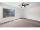 Bright bedroom featuring neutral carpet, ceiling fan, and a large window overlooking the backyard at 8920 N 56Th Ave, Glendale, AZ 85302