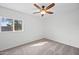 This simple bedroom features a ceiling fan, neutral carpet and paint, and large window at 8920 N 56Th Ave, Glendale, AZ 85302