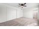 Bright bedroom featuring a ceiling fan, neutral carpet, and a closet with sliding doors at 8920 N 56Th Ave, Glendale, AZ 85302
