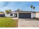 Front exterior view of a charming single-story home with a well-kept lawn and a two-car garage at 8920 N 56Th Ave, Glendale, AZ 85302