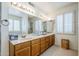 Bathroom featuring wood cabinetry with dual sinks, a large mirror, and a shower at 9420 W Taro Ln, Peoria, AZ 85382