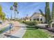 Landscaped backyard area with desert plants, a sidewalk, and a view of the community pond at 9420 W Taro Ln, Peoria, AZ 85382