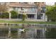 Waterfront home featuring a balcony, palm trees, and ducks swimming in the pond at 971 E Driftwood Dr, Tempe, AZ 85283