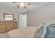 Comfortable bedroom featuring a bed, dresser with mirror, closet doors, ceiling fan and a window that provides natural light at 1145 E Silktassel Trl, San Tan Valley, AZ 85143