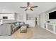 Bright living room with a large sectional, ceiling fan, and views into the kitchen area at 1145 E Silktassel Trl, San Tan Valley, AZ 85143