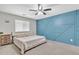 Comfortable bedroom features a ceiling fan, grey carpet, blue accent wall and a window that provides natural light at 1145 E Silktassel Trl, San Tan Valley, AZ 85143