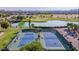 Aerial shot showcasing community tennis courts near a pond, offering a blend of recreation and serene views at 1145 E Silktassel Trl, San Tan Valley, AZ 85143